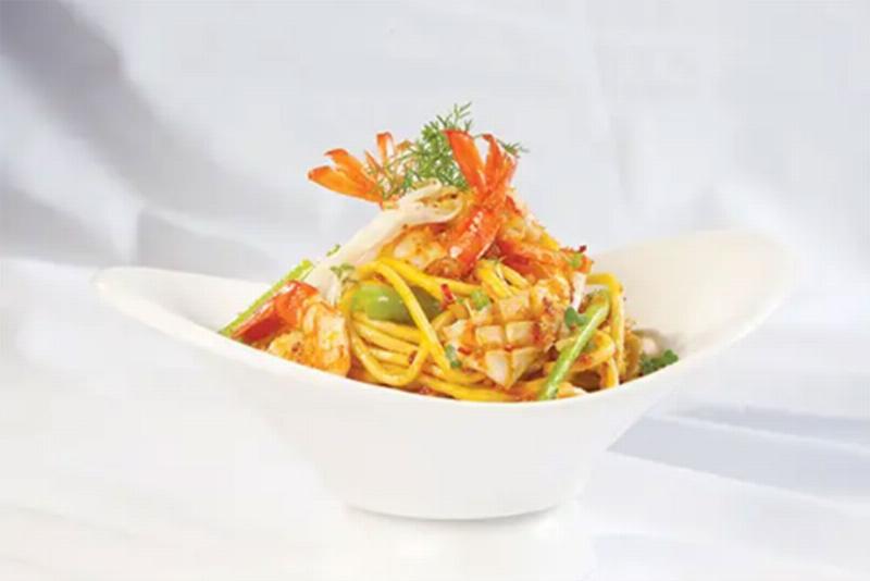 Hình ảnh tôm và mực đang được xào nhanh trên chảo nóng với lửa lớn